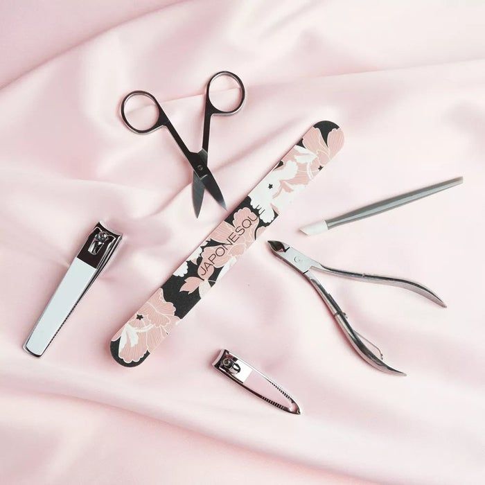 Manicure tools including scissors, clippers, cuticle pusher, and floral emery board on display