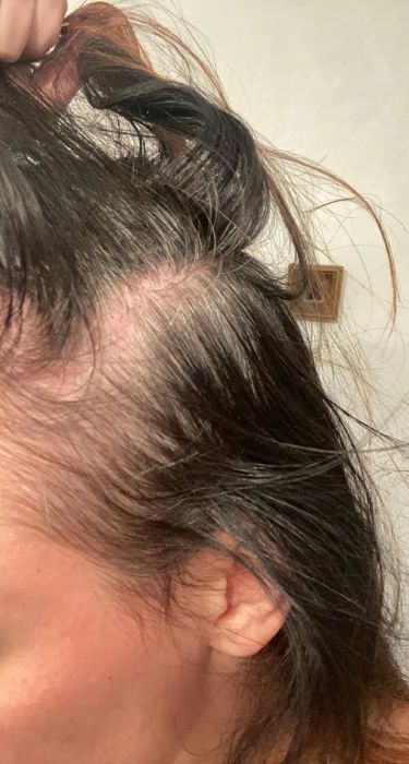 Reviewer displaying their hair before using the root cover-up spray, with visible greys showing