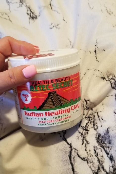 A reviewer holding the jar of the face mask.