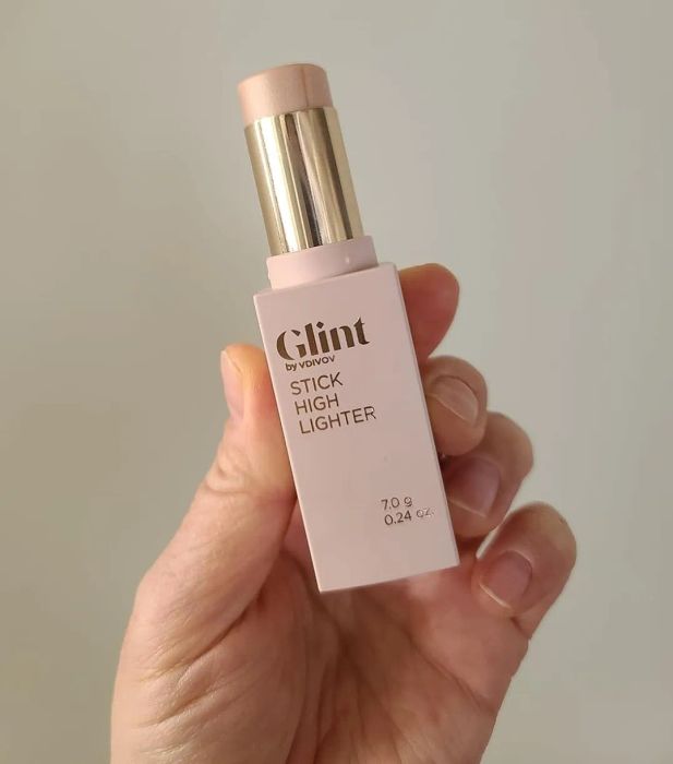 A hand holding the Glint highlighter stick