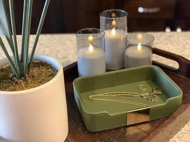 A reviewer's photo showing three LED candles lit and arranged on a tray.