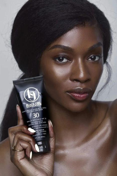 Model holding and wearing the sunscreen
