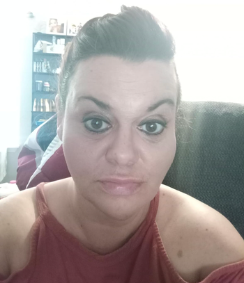 A reviewer showcasing their makeup after using the color corrector, with dark marks completely covered.