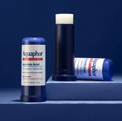 Aquaphor Healing Balm Stick for fast relief of chapped, irritated skin, shown both upright and lying flat