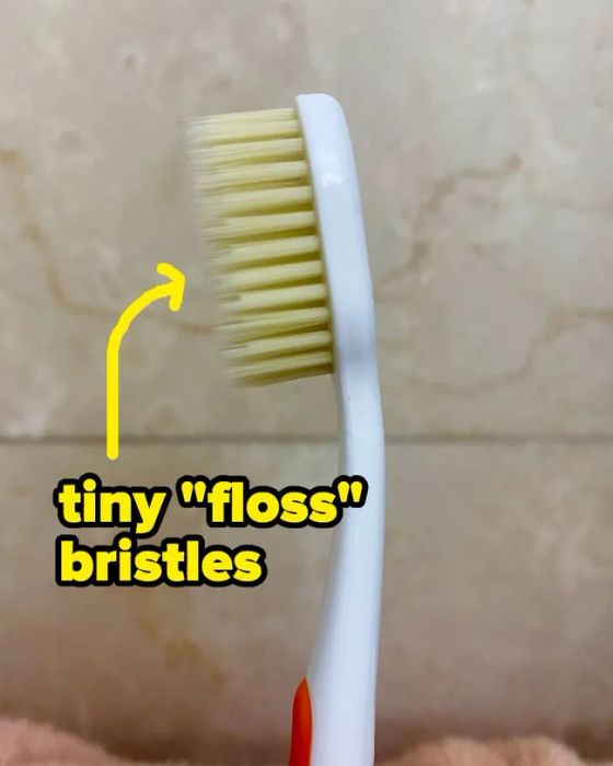 A toothbrush with two distinct layers of bristles: one longer and thinner, the other shorter and thicker.