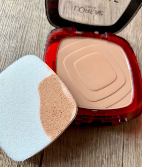 reviewer's compact open, showing the powder and the sponge with product on it