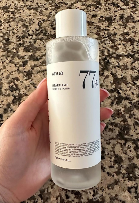 A reviewer holding the bottle of toner.
