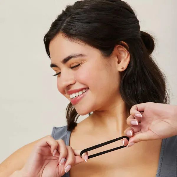 A model holding a black hair elastic