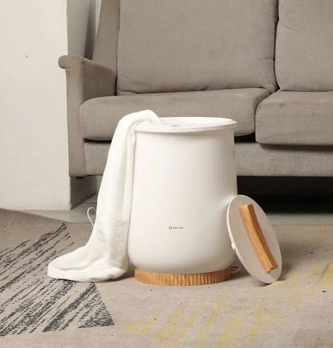 A reviewer's photo of a towel warmer with a towel hanging out, ready for use.