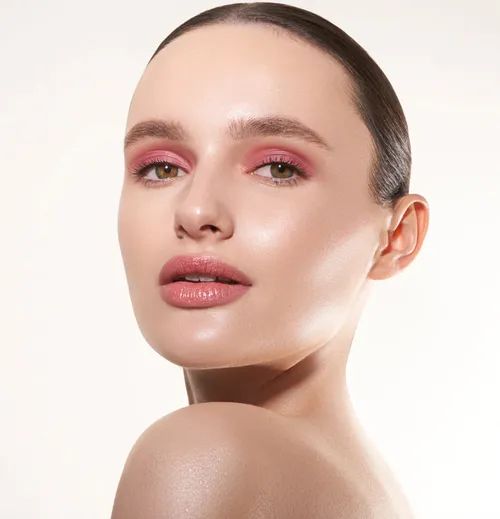 a model sporting a soft pink shade on their eyes and lips