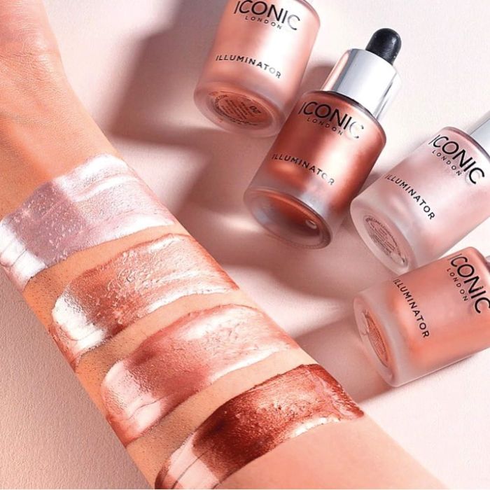 Swatches of five different highlighter shades on a forearm next to their respective ICONIC bottles