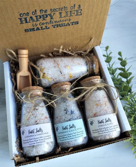 A gift box filled with four glass jars of bath salts, each labeled with delightful scents like Lavender & Chamomile, Peppermint & Eucalyptus, and Jasmine Rose & Ylang Ylang.