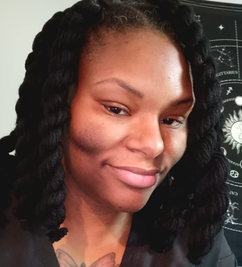 A reviewer after using the dark spot soap bars, displaying visibly improved skin with fewer dark spots and an even tone.