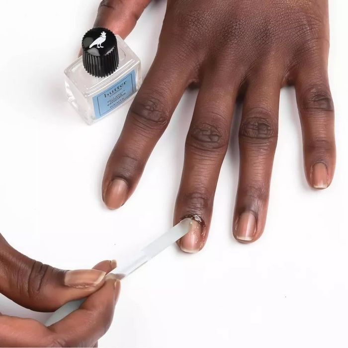 A model applying the cuticle exfoliator to their nails, giving them a polished and healthy look