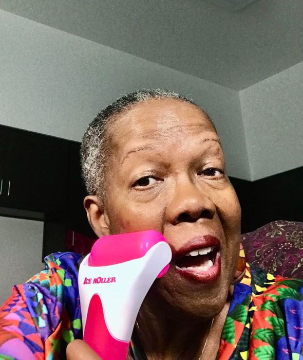 A reviewer shows how to use an ice roller on her face, demonstrating its effectiveness.