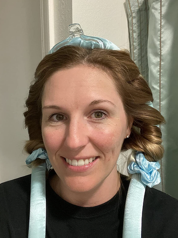 A reviewer with a headband woven into their curly hair.