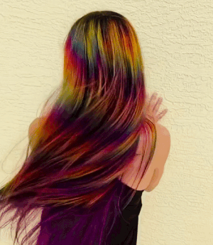 A gif showing a reviewer tossing their vibrant, rainbow-colored hair