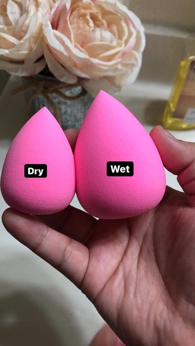 A reviewer demonstrating the difference between a wet and dry makeup sponge