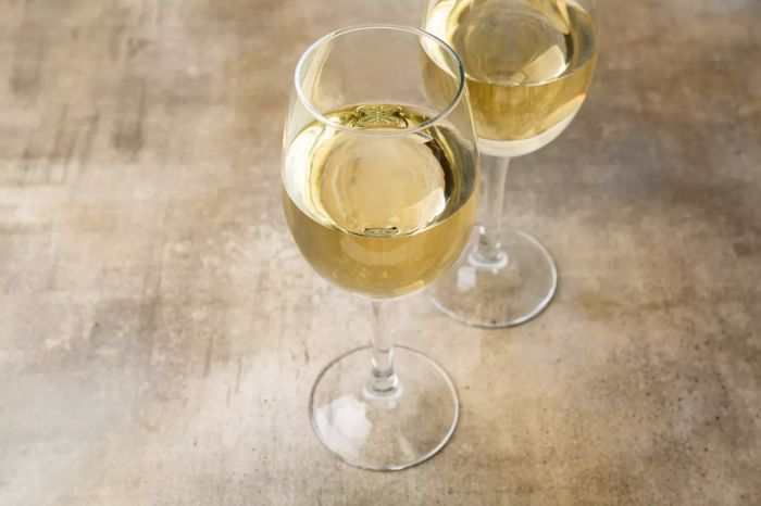 Two glasses of white wine on a surface