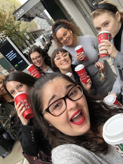 A Mytour editor rocking the bold red lipstick while posing with friends, all holding Starbucks cups