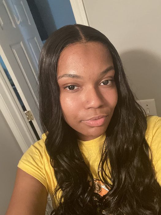 A reviewer wearing a sleek and shiny wig