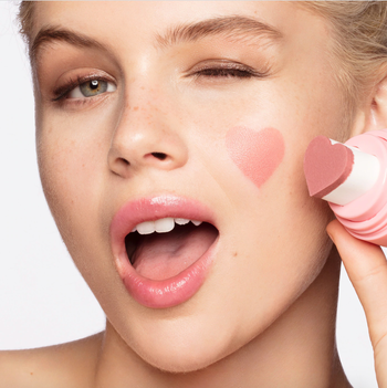 A model with a pink heart stamped on her cheek
