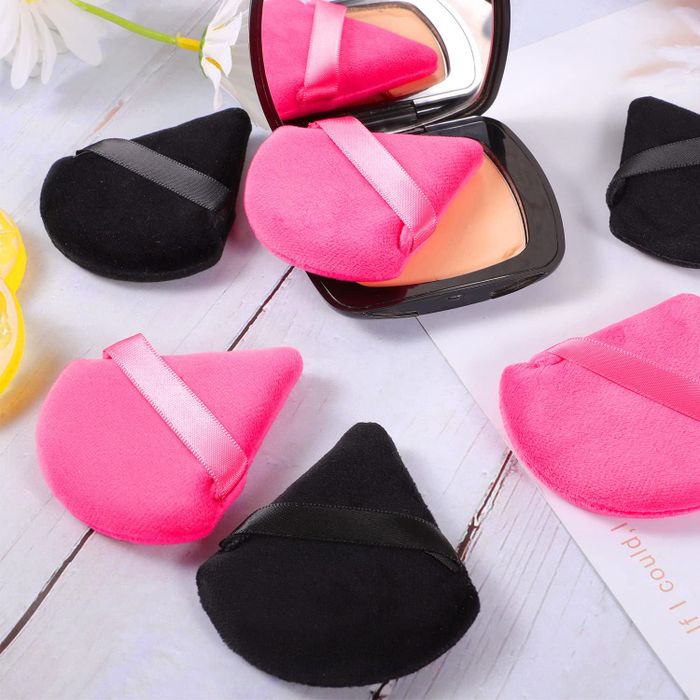 A set of triangular powder puffs in pink and black.