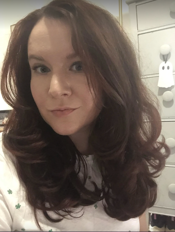 Reviewer with voluminous, blown-out hair that radiates volume.