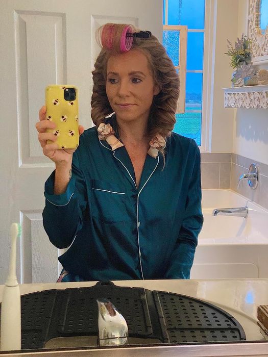 A reviewer with their hair wrapped in satin curlers overnight