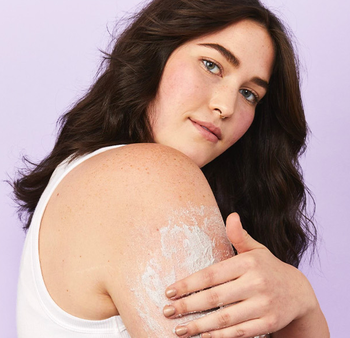 Model applying the KP scrub to their skin