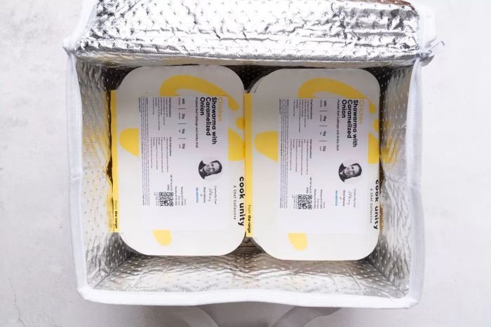 Trays of prepared meals inside a silver-colored cooler bag