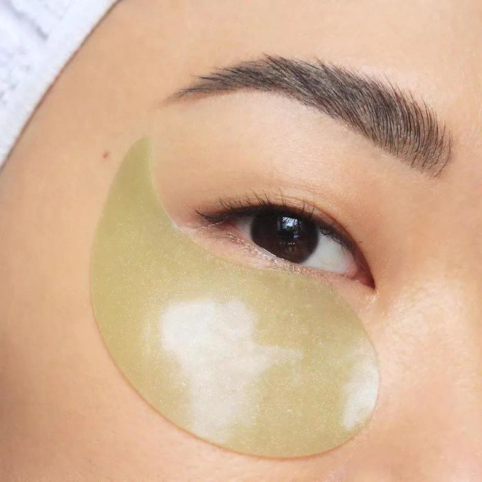 Close-up shot of a model's eye with a translucent under-eye gel patch, highlighting a beauty or skincare product.