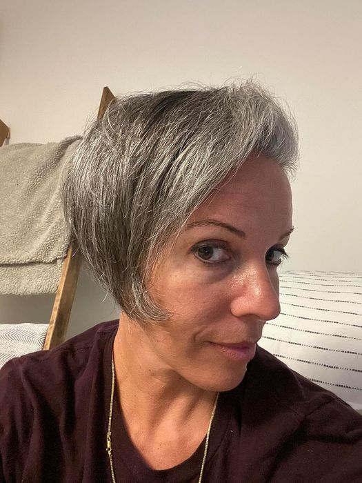 Close-up profile of the same reviewer with short, styled hair after applying the anti-humidity spray