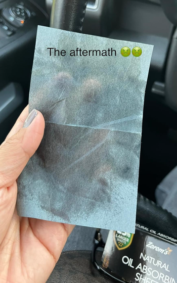 Reviewer holding an oil-absorbing sheet after use.