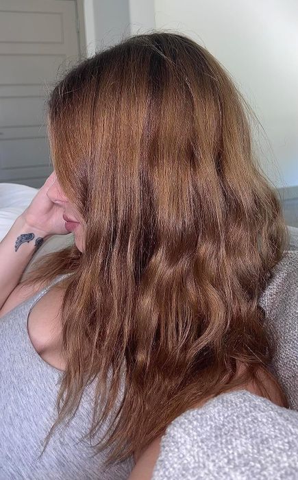 A reviewer showcasing their smooth, shiny hair