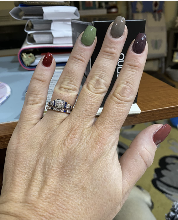 Reviewer showing off nails painted in a mix of red, green, brown, and gray shades