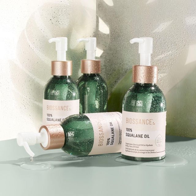 Four green pump bottles filled with the squalane oil.
