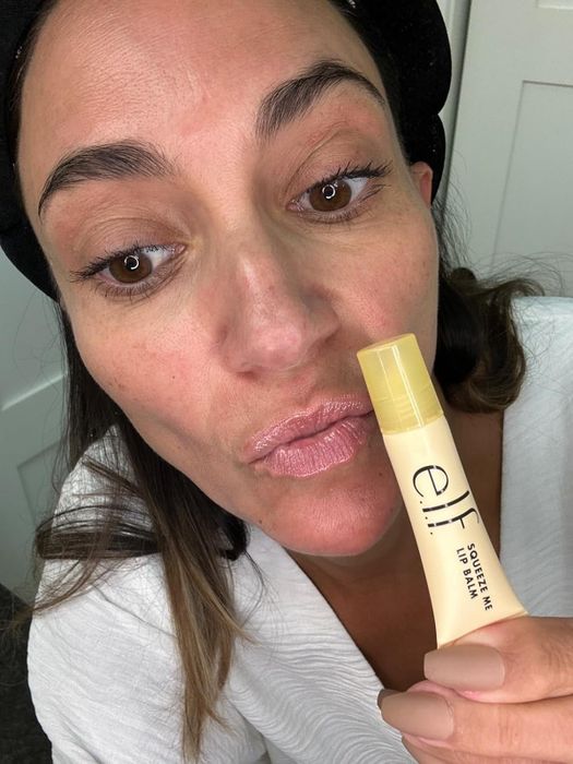A person applying e.l.f. Squeeze Me Lip Balm, close-up shot of puckered lips