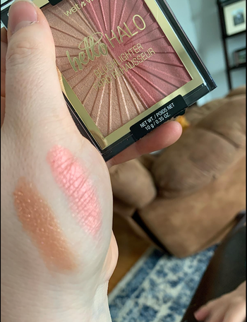 Reviewer holding a dual gold and pink palette, with swatches of the product displayed on their hand.