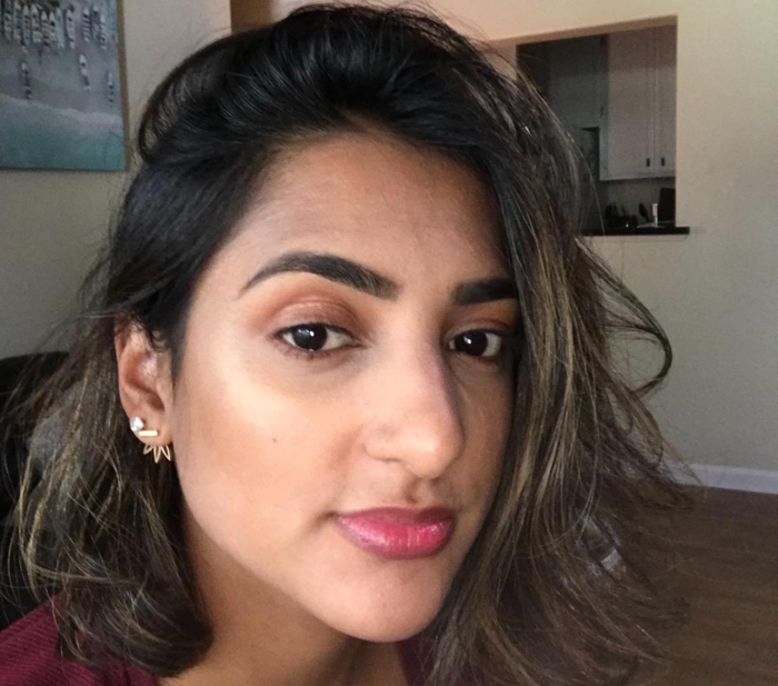 Another reviewer sporting dewy makeup and using a concealer stick.