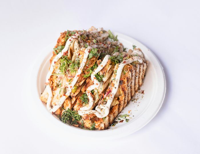 a white plate stacked high with a variety of food