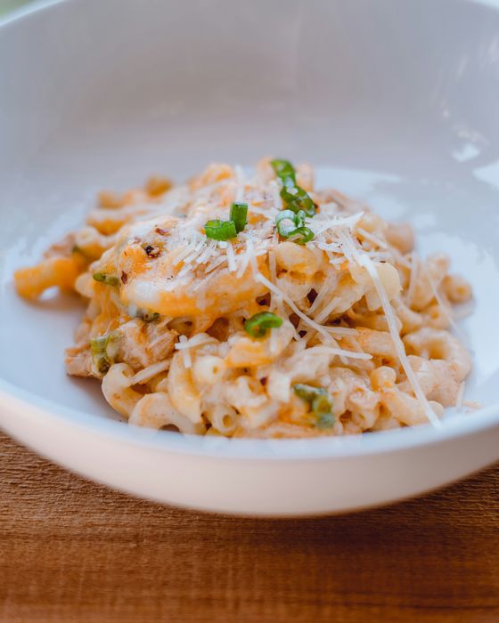 pasta with a green leaf on a white ceramic plate
