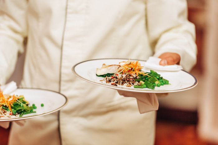 hands holding two plates of food