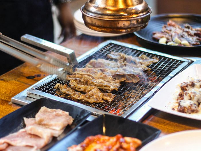 A person grilling meat on a barbecue grill