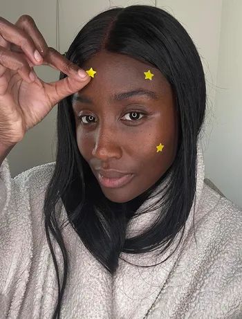 A reviewer with multiple yellow pimple patches on their face