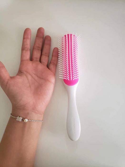 Reviewer’s hand resting next to a white brush on a table