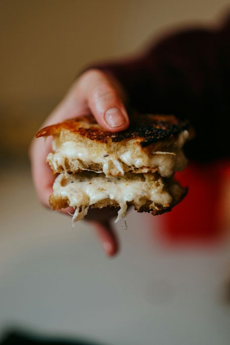 someone holding a piece of brown and white bread