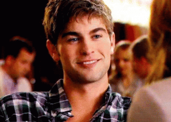 Nate grinning while dressed in a casual plaid shirt, enjoying a social gathering
