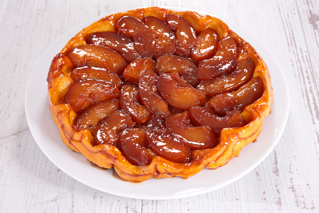 A plate of Tarte Tatin, with caramelized apple slices arranged on a white plate, showcasing its glossy finish and rich texture.