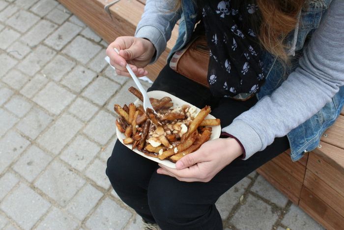 someone holding a burger with fries